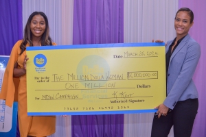 Tashoni Ellis, Group Marketing Manager of Dolla Financial Services (left), and Trevene McKenzie, Chief Financial Officer at Dollar Financial Group, proudly display the symbolic one million dollar check during the official Million Dolla Woman Handover Ceremony. The moment unfolds on Tuesday in conjunction with the Jamaica Stock Exchange&#039;s Potential Junior Market Luncheon at the JSE Building.