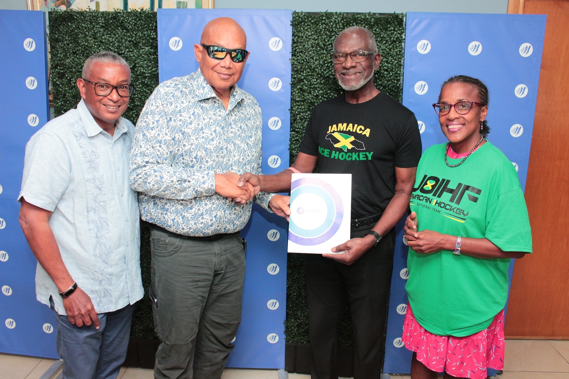 (from left to right) Konrad Mark Berry, Vice Chairman of Mayberry Investments, and Chris Berry, Executive Chairman of Mayberry Investments Limited, unite with Don Anderson, President of the Jamaican Olympic Ice Hockey Federation, and Dr. Denise Forrest, Director of the Jamaican Olympic Ice Hockey Federation, in a collaborative effort during the recent handover ceremony at Mayberry Investments Limited.