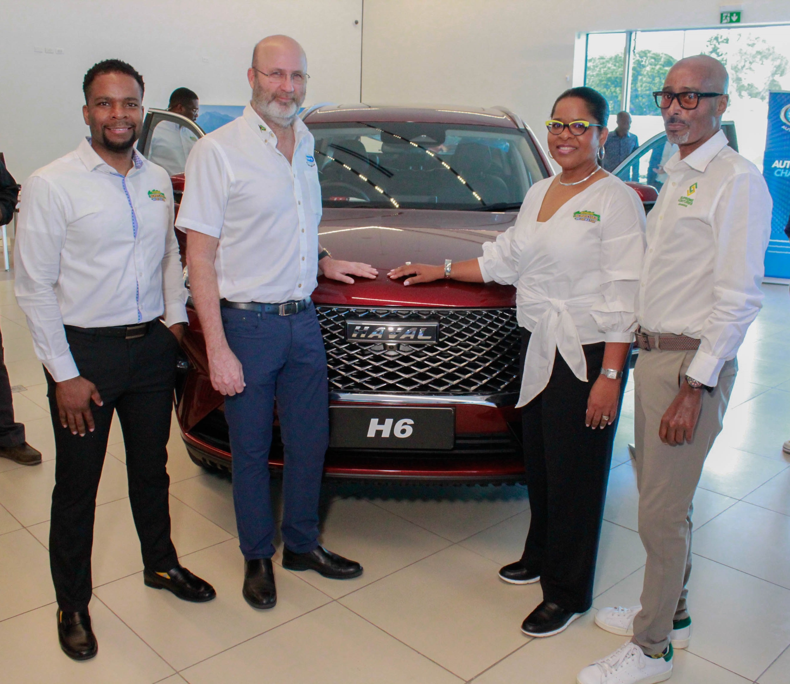 Presenting the dynamic quartet showcasing the sleek and stylish 2024 GVM Haval H6 at the Supreme Wheels Launch on Wednesday. (From left to right), Senior Vice President for Products and Business, Stefan Miller; Managing Director of Stewart's Automotive Group, Duncan Stewart; General Manager at IGT, Debbie Green; and Supreme Ventures Gaming CEO, Xesus Johnston. 