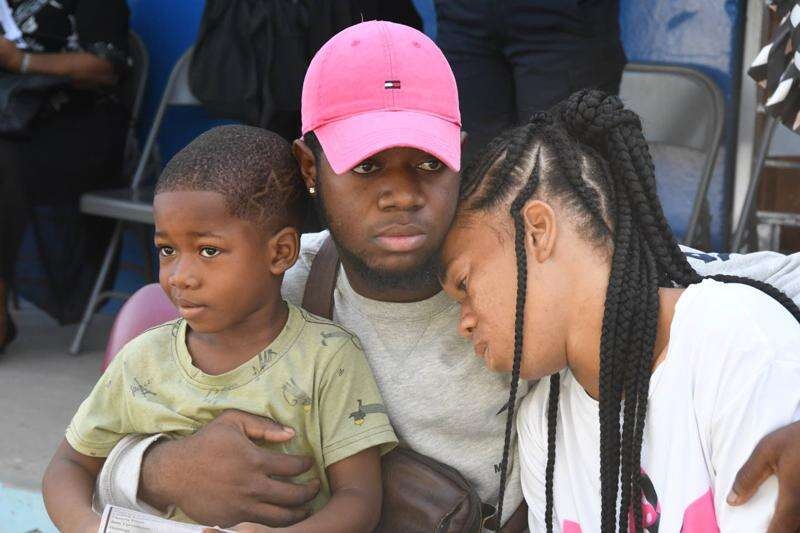 Danielle Rowe's little brother Jamari Taylor (left), cousin Kevon Rowe, and mother Sudiene Mason are a picture of grief during morning devotion at Braeton Primary and Infant School on Monday.