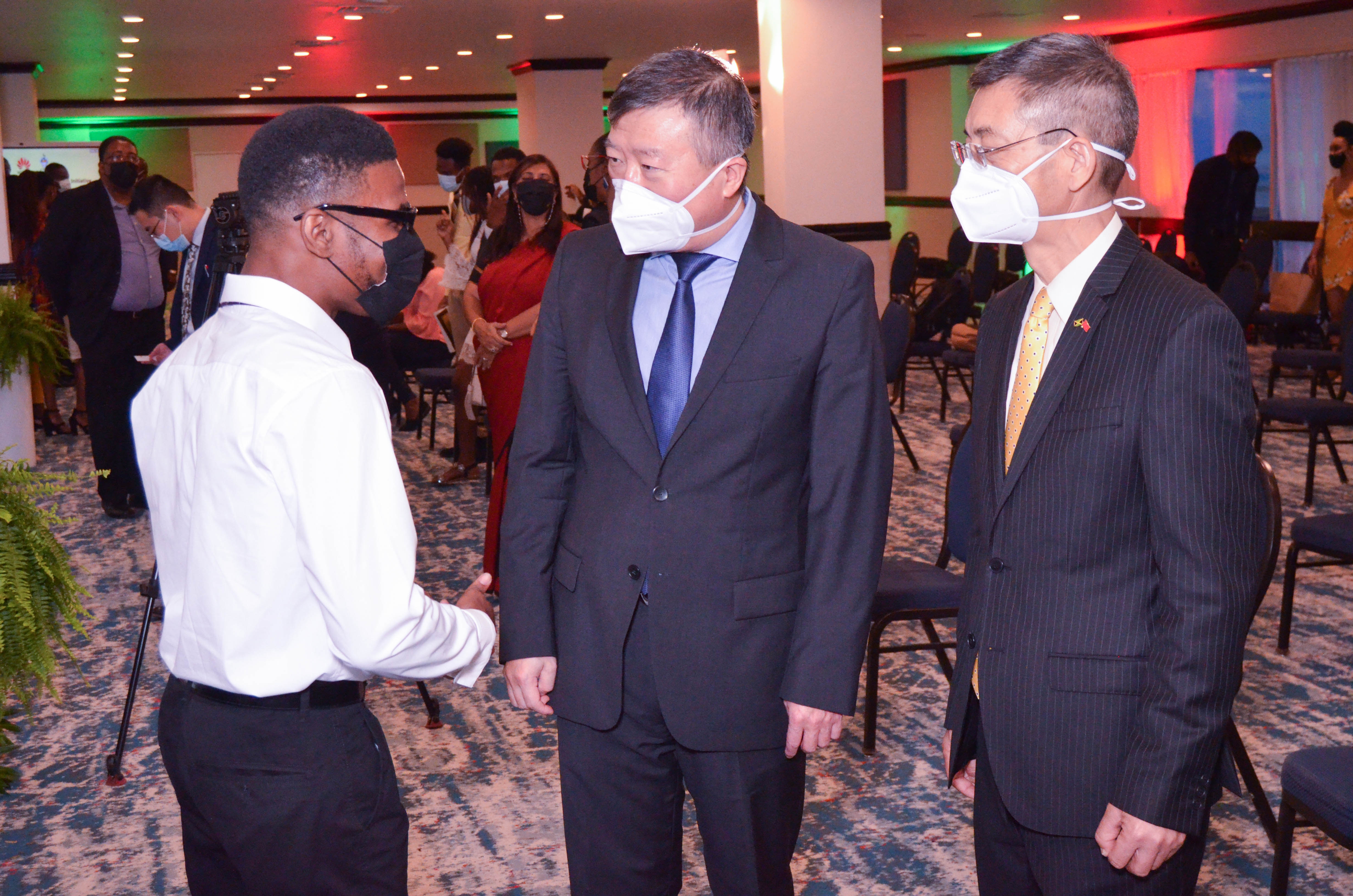 Top University of the West Student Shemar Jones has the full attention of His Excellency Ambassador,People's Republic of China to Jamaica H.E Tian Qi along with counselor Fan Jiang Hong after the Seeds for the Future Graduation last year.