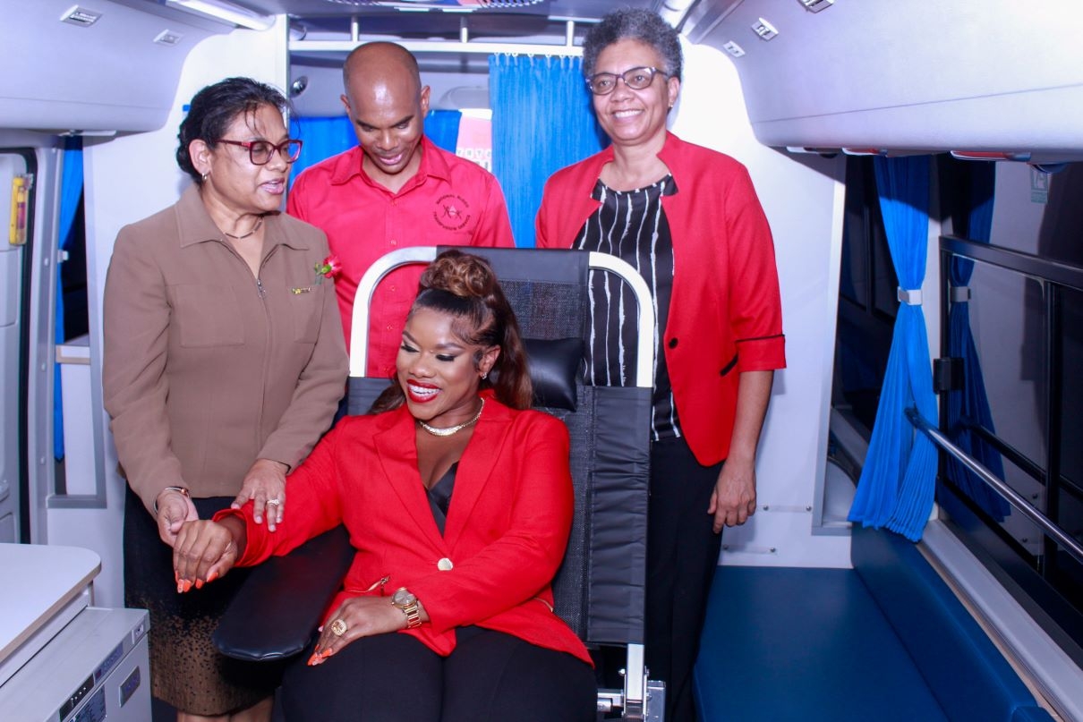 Khadine 'Miss Kitty' Hylton (seated) tests out the Blood Bank's new mobile unit at the World Blood Donor Day Ceremony on Wednesday. Joining in the moment at the National Blood Transfusion Service are (from left) Dr. Jacquiline Bisasor-McKenzie, Chief Medical Officer- MOHW, Igol Allen, Blood Donor Organizer, and Dr. Marlene Tapper, Acting Director- National Laboratory Service