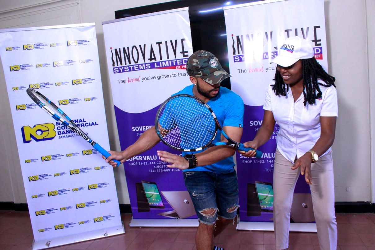 Seretse Bell (left)  teaches Yanique Hall, Sales & Marketing Manager- Innovative Systems Limited, a few techniques at the launch of the 2023 Innovative Invitational Amateur Tennis Classic on Tuesday at the Liguanea Club.