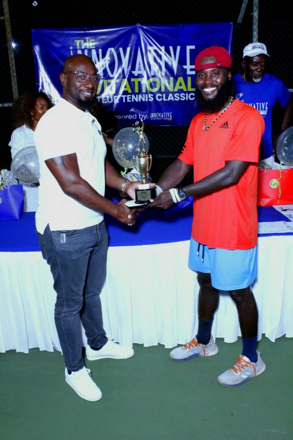 Garth Walker, Executive Chairman, Innovative Systems Limited, presents the winning prize to Jeremy Miller, winner of the Men&#039;s Open at the 2023 Innovative Invitational Amateur Tennis Classic finals at the Liguanea Club.