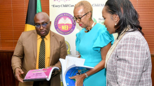 Minister of Education and Youth Fayval Williams (centre); Chief Education Officer (acting) in the Ministry, Dr Kasan Troupe (right) and President-elect, Jamaica Teachers’ Association (JTA), Leighton Johnson, look at the Civics Curriculum for various grades, which has been reintroduced in the National Standards Curriculum. The launch of the programme was held at the ministry in Kingston on December 13. (Photo: JIS)