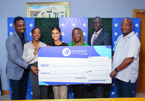 Standing proudly behind the symbolic $1 million dollar check courtesy of Mayberry Investments are (from left to right) Junior Roberts, Investment Advisor at Mayberry Investments; Desiree Wheeler, Senior Marketing Officer at Mayberry Investments; Vice President of Marketing, Stephanie Harrison; Nicole Grant-Brown, President of Gymnastics Jamaica; Rayon Wright, Investment Advisor at Mayberry; and Beriah Boothe. This united force symbolises Mayberry&#039;s unwavering commitment, standing tall during the launch ceremony of the Pan American Youth Gymnastics Tournament on Tuesday.