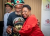 The Minister of Culture, Gender, Entertainment and Sport, the Honourable Olivia Grange, embraces Edward Fray, a survivor of the 1963 Coral Gardens incident, after the formal establishment of the Trust in December 2019.  Also pictured is Isaac Wright, another survivor.