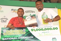 Dwayne Tulloch (right), Senior Vice President of Retail and Customer Operations at Supreme Ventures Limited, presents the $1 million winning check to Wilfred Barnes, the newly crowned National Domino Champion, during the Supreme Domino Masters Series Finals, at the prestigious Chinese Benevolent Association (CBA) on Sunday.