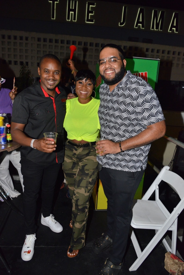  Danielia McLean, Magnum Tonic Wine&#039;s Project Manager, is sandwiched by Regional Marketing Manager, Kamal Powell, and Brand PR &amp; Communications Manager, Dominic Bell, on Saturday at the Magnum All-Star Sound Clash Final on Ocean Boulevard. 