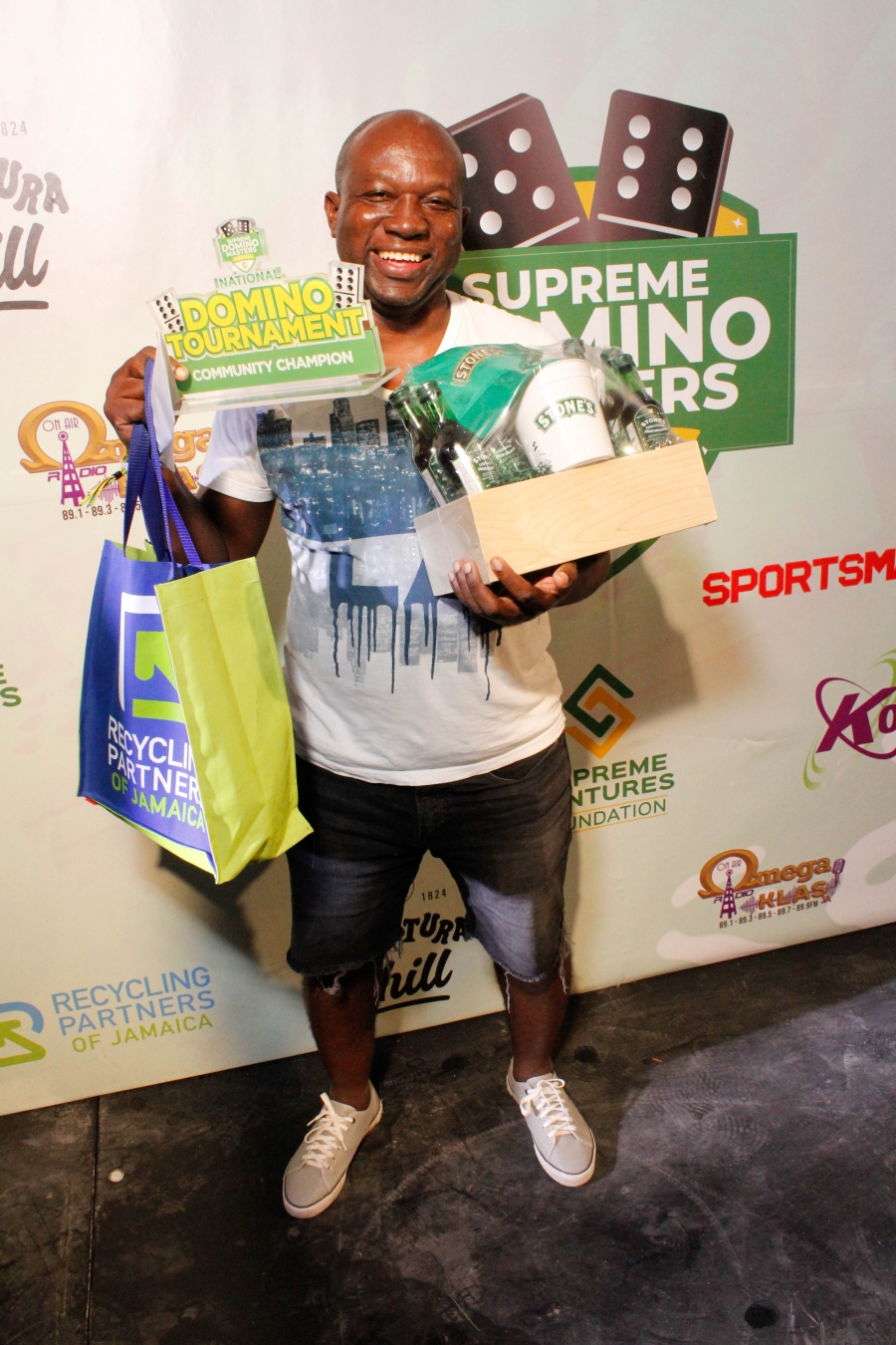Garfield Brissett exudes sheer excitement as he poses with his winning prizes on Sunday at Maggie’s Sports Bar at the Supreme Domino Master Series.
