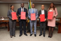 Members of the executive of the Jamaica Police Federation, including Chairman, Corporal Rohan James (second left), pose for the camera with the signed wage deal for rank-and-file police personnel alongside Finance and the Public Service Minister, Dr Nigel Clarke (centre), and National Security Minister, Dr Horace Chang (second right).
